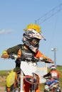 Side view of an boys performing stunt with motorcycle on motocross track