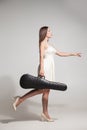 Side view of brunette in white dress carries violin in case Royalty Free Stock Photo