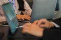 Side view of business woman's hands using laptop computer resting, young woman writing in blank notebook Royalty Free Stock Photo