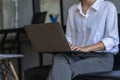 Side view of business woman's hands using laptop computer resting, young woman writing in blank notebook Royalty Free Stock Photo