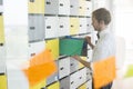 Side view of businessman putting files in locker at creative office Royalty Free Stock Photo