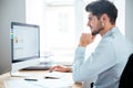 Side view of businessman sitting using personal computer in office Royalty Free Stock Photo