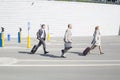 Side view of businesspeople with luggage walking on street