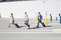 Side view of businesspeople with luggage walking on street