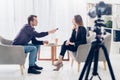 Side view of businesswoman in suit giving interview to journalist with voice recorder Royalty Free Stock Photo