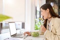 Side view of a busy and hungry asian businesswoman having lunch at her desk while working Royalty Free Stock Photo