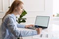 Beautiful woman with laptop and documents at home