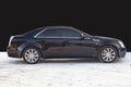 Side view of Cadillac CTS in black color after cleaning before sale in a winter day background on parking above black wall