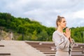 Side view of calm Caucasian young woman practicing yoga performing namaste pose outside in city park. Royalty Free Stock Photo