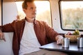 Side View On Calm Male Sitting Behind Table In Mini Van, Looking At Side, Having Rest Royalty Free Stock Photo