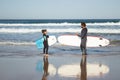 Side view of caring family of surfers holding surfboards Royalty Free Stock Photo