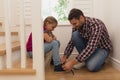 Father tying his daughter shoelaces in a comfortable home