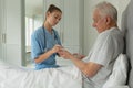 Female doctor giving medicine to active senior patient in bedroom Royalty Free Stock Photo