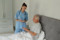 Female doctor giving medicine to active senior patient in bedroom Royalty Free Stock Photo