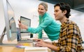 Male and female graphic designer discussing over computer at desk Royalty Free Stock Photo