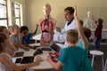 Male teacher wearing a lab coat using anatomy model