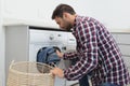Man putting dirty clothes into the washing machine in a comfortable home Royalty Free Stock Photo