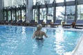 Side view of a Caucasian woman resting at poolside. She is enjoying a quiet weekend at the spa