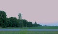 Side view of Caucasian young countryman carrying shovel on shoulder while walking in farmland in evening. Male farmer in Royalty Free Stock Photo