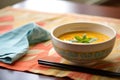 side view of a ceramic bowl filled with tomato basil soup on a linen napkin Royalty Free Stock Photo