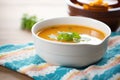 side view of a ceramic bowl filled with tomato basil soup on a linen napkin Royalty Free Stock Photo