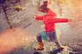 Adorable girl playing in puddle outside Royalty Free Stock Photo