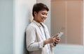 Side view cheerful asian man using cell phone outdoors Royalty Free Stock Photo