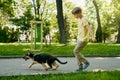 Cheerful boy running with puppy at summer park Royalty Free Stock Photo
