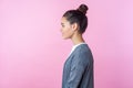 Side view of cheerful brunette teenage girl smiling, looking kind and positive, empty copy space for advertisement. pink