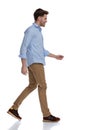 Side view of cheerful casual man smiling while walking Royalty Free Stock Photo