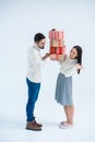 side view of cheerful multicultural couple looking at each other while holding stack of wrapped christmas gifts Royalty Free Stock Photo