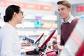 Cheerful pharmacist holding two packs of medicine giving advices