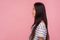 Side view of cheerful pretty asian girl with long brunette hair in striped t-shirt looking at copy space with smile Royalty Free Stock Photo