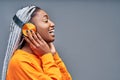 Side view of a cheerful young african woman listening to music with headphones isolated over grey background Royalty Free Stock Photo