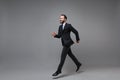 Side view of cheerful young business man in classic suit shirt tie posing isolated on grey background. Achievement Royalty Free Stock Photo