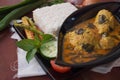 Side view of chicken basil with rice on a wooden table