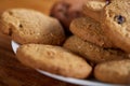 Side view of chocolate chip cookies on a wooden plate over rustic background, selective focus Royalty Free Stock Photo