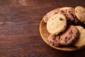 Side view of chocolate chip cookies on a wooden plate over rustic background, selective focus Royalty Free Stock Photo