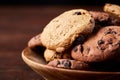 Side view of chocolate chip cookies on a wooden plate over rustic background, selective focus Royalty Free Stock Photo