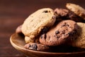 Side view of chocolate chip cookies on a wooden plate over rustic background, selective focus Royalty Free Stock Photo