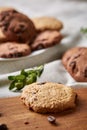 Side view of chocolate chip cookies on a wooden plate over rustic background, selective focus Royalty Free Stock Photo