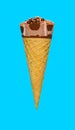 side view of chocolate flavor ice cream cone on a blue background Royalty Free Stock Photo