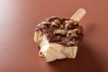 Side view chocolate outer ice cream with peanuts on a brown background with bites