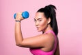 Side view of chubby mulatto woman holding dumbbell