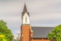 Side view of church exterior with focus on steeple and roof against cloudy sky Royalty Free Stock Photo
