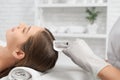 Young woman on procedure for improvements hair in salon.