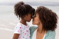 Mother and daughter rubbing noses at beach on a sunny day Royalty Free Stock Photo