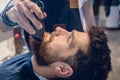 Close-up of the head of a man and the hand of a barber trimming