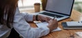 Side view and close up of woman`s hands using laptop and writing in notepad. Working on project concept Royalty Free Stock Photo