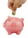 Side view closeup of man hand inserting coin in piggybank isolated on white